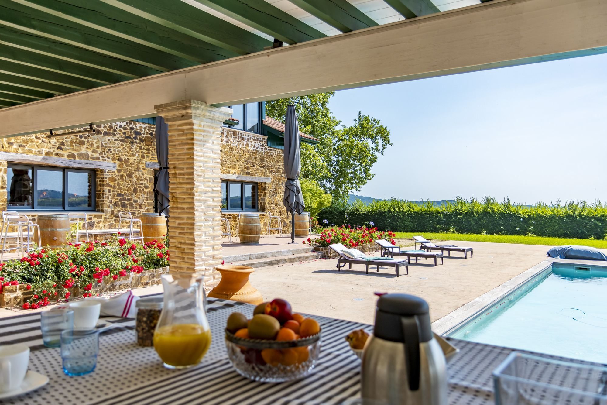 Petit-déjeuner sous la pergola face à la piscine