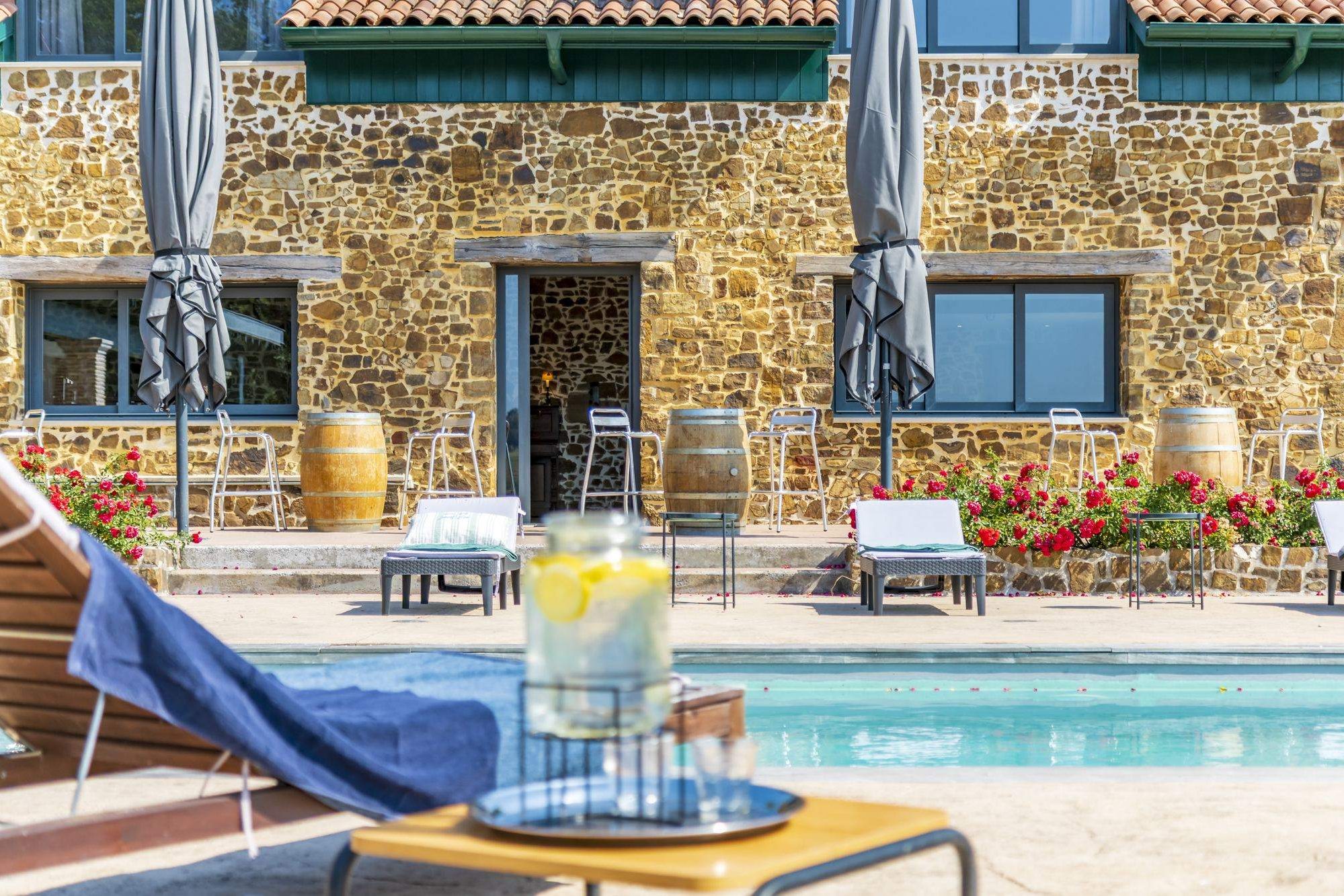 Piscine devant la façade en pierre de la Maison Marie-Louise