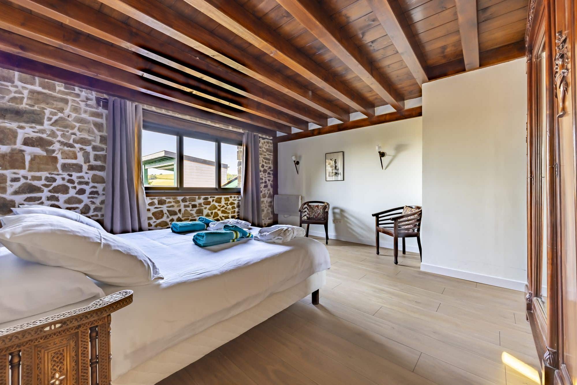 Suite avec mur en pierre et poutres apparentes
