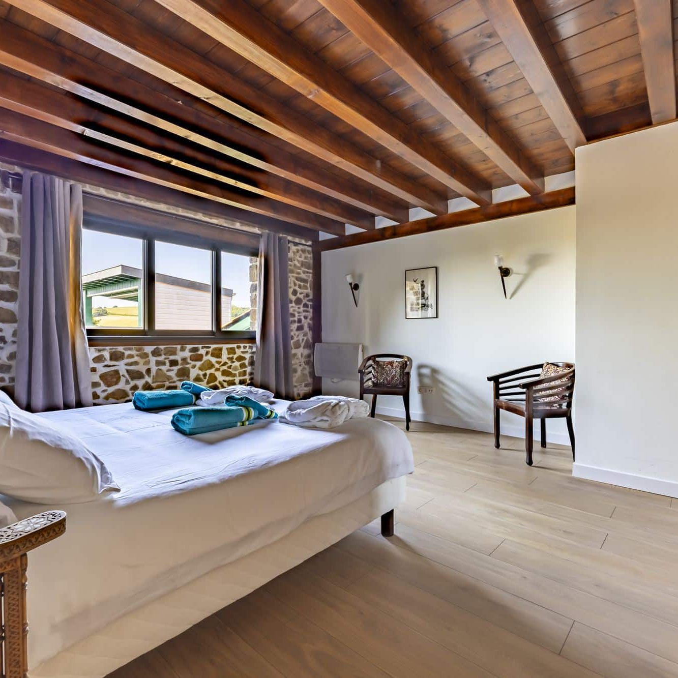 Suite avec mur en pierre et poutres apparentes